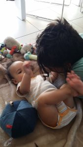 Bébé pratiquant la motricité libre, allongé sur un tapis, libre de ses mouvements